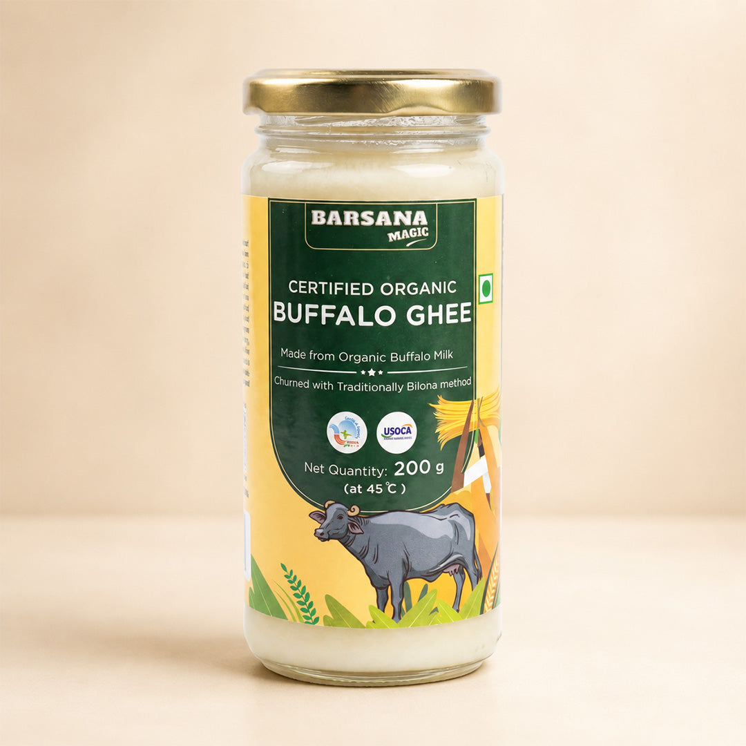 Barsana Magic and A 200g glass jar of Barsana Magic Certified Organic Buffalo Ghee, featuring a gold metal lid and a yellow and green label with a cow illustration, set against a warm beige background.
