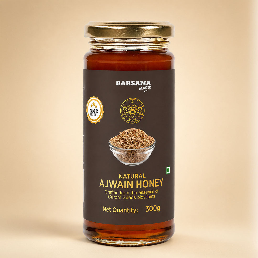 Barsana Magic and A 300g glass jar of Barsana Magic Natural Ajwain Honey, featuring a dark brown label with gold lettering and a gold metal lid, set against a solid beige background.