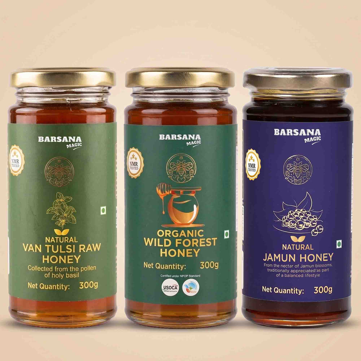 Barsana Magic and Three glass jars of Barsana Magic honey products lined up against a solid beige background. The jars contain amber-colored honey and are fitted with gold lids.