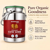 Barsana Magic and A stainless steel milk container with a red label reading 'Barsana Organic Cow Ghee' on a beige background, alongside marketing text about pure organic goodness and traditional bilona method.