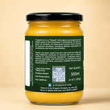 Barsana Magic and A 500ml glass jar of Badgi Cow Organic Cow Ghee, showing the yellow ghee through the clear glass and a dark green label with white text and a QR code, topped with a black lid, set against a solid beige background.
