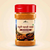 Barsana Magic and A bottle of Bhusaka Tendu Pahadi Namak (Marination Mix) containing a brownish-orange spice blend, with a red cap and a cream-colored label, set against a light beige background.