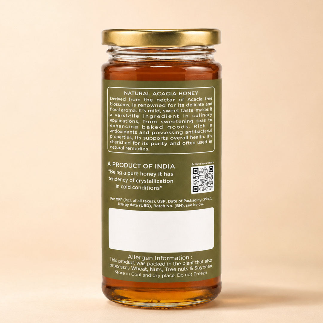 Barsana Magic and A glass jar of natural acacia honey with a gold metal lid and a dark olive green label, shown from the back against a solid beige background.