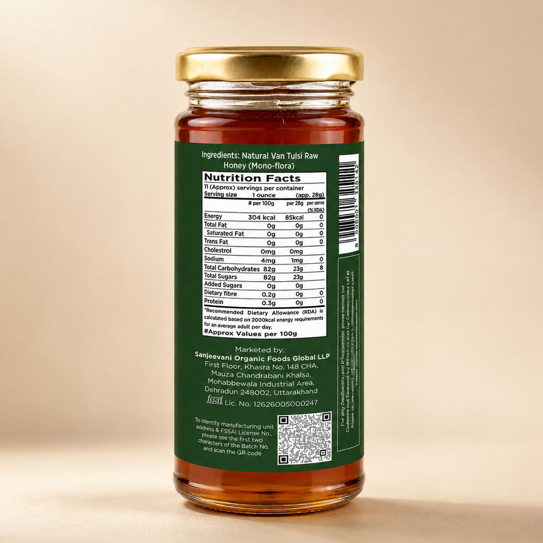 Barsana Magic and A glass jar of raw honey shown from the back, featuring a dark green label with a visible Nutrition Facts panel and a gold metal lid, set against a warm beige background.