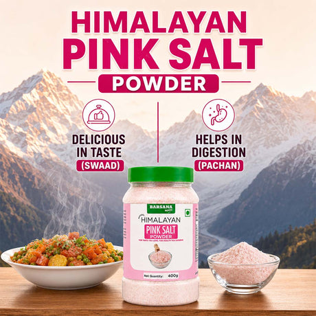 Barsana Magic and A jar of Ramada Himalayan Pink Salt Powder is displayed on a wooden table with a bowl of colorful cooked food on the left and a small bowl of loose pink salt on the right, set against a mountain backdrop with promotional text.