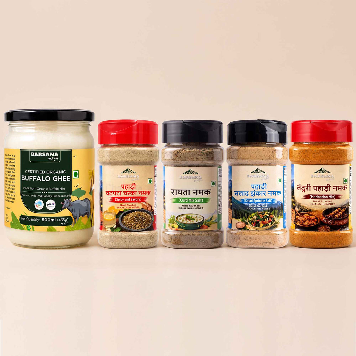 Barsana Magic and Five BarSana brand spice and ghee containers arranged in a row on a light beige background. The set includes a large jar of Buffalo Ghee on the left and four spice jars with red, beige, black, and red lids on the right.