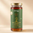 Barsana Magic and A 300g glass jar of Barsana Magic Natural Van Tulsi Raw Honey with a gold lid and a dark green label, set against a warm beige background.