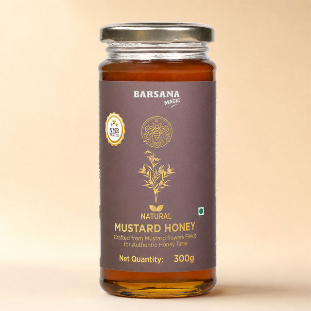 Barsana Magic and A 300g glass jar of Barsana Magic Natural Mustard Honey, featuring a dark brown label with gold lettering and illustrations, topped with a silver metal lid, set against a solid beige background.