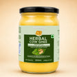 Barsana Magic and A 500ml glass jar of Bansana Herbal Cow Ghee with a black lid and a light green and dark green label, set against a solid beige background.