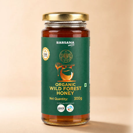 Barsana Magic and A 300g glass jar of Barsana Magic Organic Wild Forest Honey with a gold lid and a dark green label, set against a solid beige background.