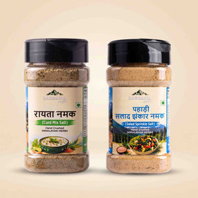 Barsana Magic and Two plastic spice jars of Haritabha Brand shown side by side on a light beige background. The left jar is labeled 'Raita Namak (Cure Mix Salt)' and the right jar is labeled 'Pahadi Salad Zikkar Namak' in both Devanagari and English text.