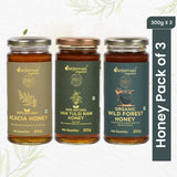 Three jars of natural honey—Wild Forest, Van Tulsi, and Acacia—arranged together, showcasing their golden, amber hues.