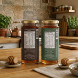 Barsana Magic and Two jars of honey with labels on a wooden table in a kitchen setting.