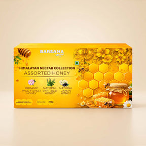 Barsana Magic and A yellow rectangular box of Barsana Magic Himalayan Nectar Collection Assorted Honey, featuring illustrations of honeycombs, bees, flowers, and honey pots on a beige background.