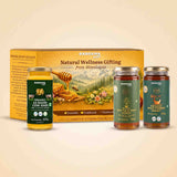 Barsana Magic and Natural Wellness Gifting set featuring a large golden-yellow box, a jar of organic AS Badhi Cow Ghee, and two jars of honey (Van Tulsi Raw Honey and Organic Wild Kept Honey) arranged in front of the box on a light beige background.