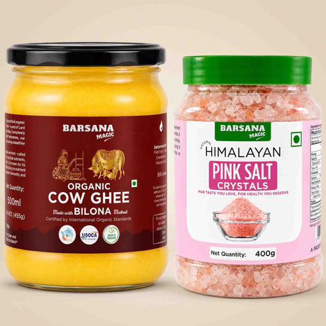 Barsana Magic and Two jars of Barsana Magic products on a beige background: a large jar of Organic Cow Ghee with a black lid and dark red label, and a smaller jar of Himalayan Pink Salt Crystals with a green lid and pink label.