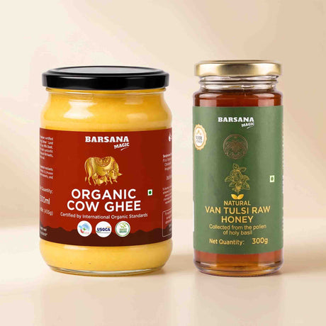 Barsana Magic and Two glass jars of products on a light beige background: a large jar of Organic Cow Ghee with a black lid and brown label, and a smaller jar of Natural Van Tulsi Raw Honey with a gold lid and green label.