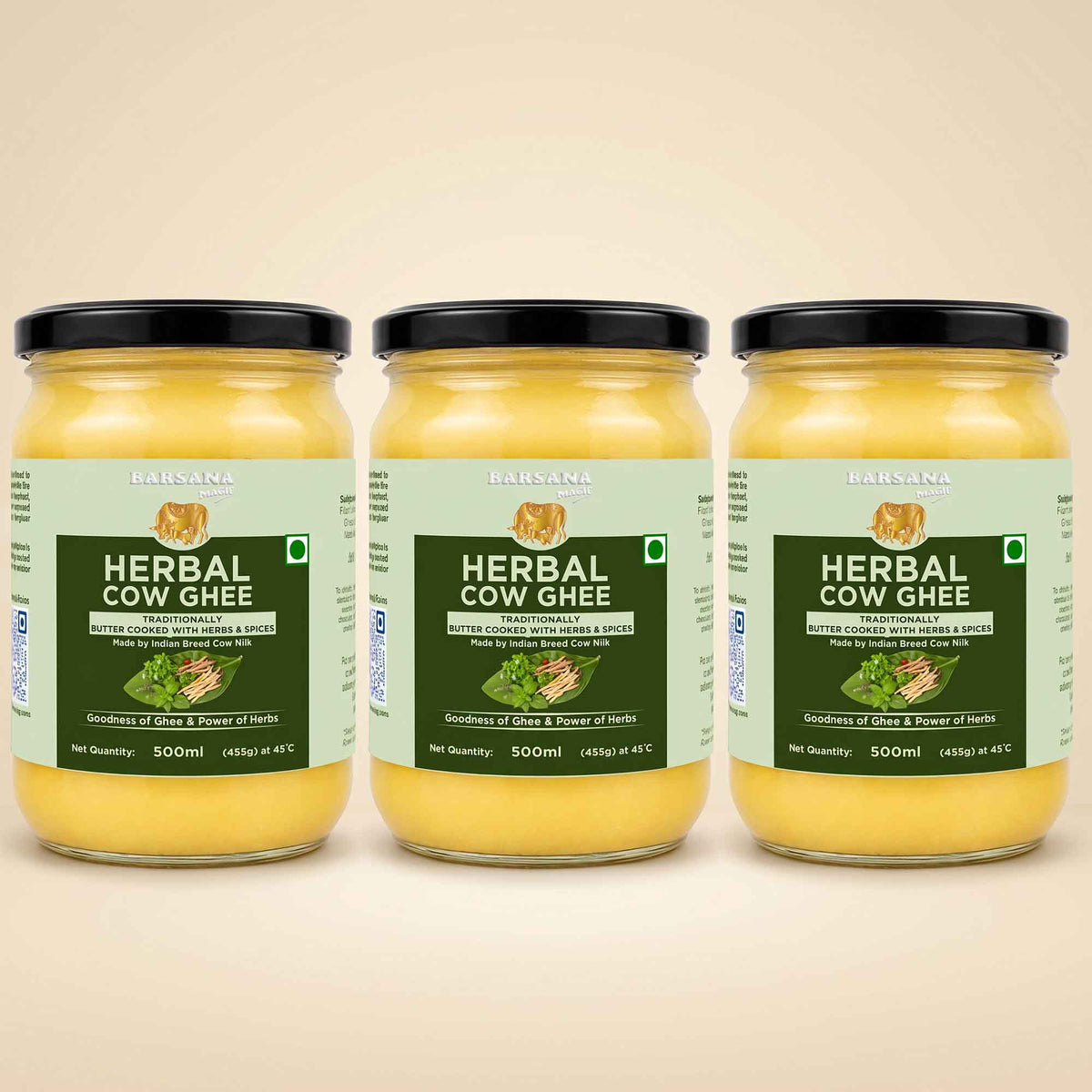 Barsana Magic and Three glass jars of Babasa Herbal Cow Ghee arranged side by side on a light beige background. The jars contain a yellow ghee and are fitted with black lids, featuring light green and dark green labels with product details.