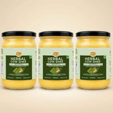 Barsana Magic and Three glass jars of Babasa Herbal Cow Ghee arranged side by side on a light beige background. The jars contain a yellow ghee and are fitted with black lids, featuring light green and dark green labels with product details.