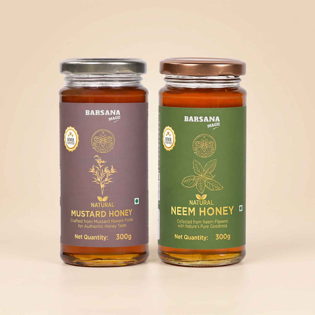 Barsana Magic and Two glass jars of Barsana Magic honey, Natural Mustard Honey on the left with a dark purple label and silver lid, and Natural Neem Honey on the right with a dark green label and bronze lid, set against a solid beige background.