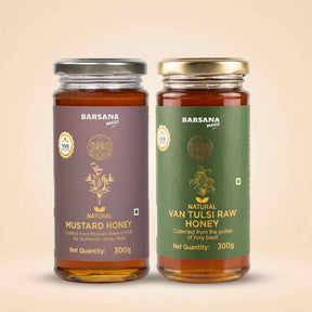 Barsana Magic and Two glass jars of Barsana Magic honey on a warm beige background. The left jar is labeled 'Natural Mustard Honey' with a dark purple label and a silver lid.