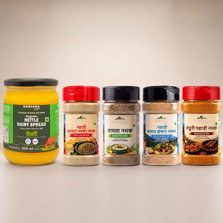 Barsana Magic and A set of five Indian spices and spreads from Barhana Brand arranged on a light beige background. The set includes a large jar of Yellow Nutle Dairy Spread on the left, followed by four clear plastic spice jars with red and black lids: Papai Chutney, Ramta Namak, Papai Samad Bhasha Namak, and Hantui Papai Namak.