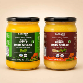 Barsana Magic and Two 500 ml jars of Barsana Organic spreads on a light beige background. The left jar contains Organic Nettle Dairy Spread with a green label, and the right jar contains Organic Herbal Dairy Spread with a dark red label.