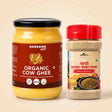 Barsana Magic and Two Barsana Magic products on a light beige background: a large glass jar of Organic Cow Ghee with a black lid and brown label, and a smaller clear plastic spice container with a red lid and beige label.