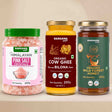 Barsana Magic and Three Barsana Magic products displayed side-by-side on a beige surface: Himalayan Pink Salt Crystals in a clear jar with a green lid, Organic Cow Ghee in a yellow jar with a gold lid, and Organic Wild Forest Honey in a dark green jar with a gold lid.