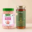 Barsana Magic and Two packaged food products on a plain beige background: a jar of Barsana Magic Himalayan Pink Salt Cystals with a green lid and pink label, and a glass jar of Barsana Magic Natural Van Tulsi Raw Honey with a gold lid and dark green label.