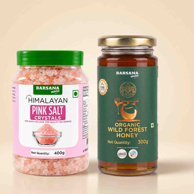 Barsana Magic and Two BarSana Magic products on a beige background: a 400g jar of Himalayan Pink Salt Cystals with a green lid and pink label, and a 300g glass jar of Organic Wild Forest Honey with a gold lid and dark green label.