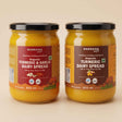 Barsana Magic and Two jars of Barsana Organic Turmeric & Garlic Dairy Spread on a warm beige background. The jars are filled with a thick yellow-orange spread and feature brown and red labels with black lids.