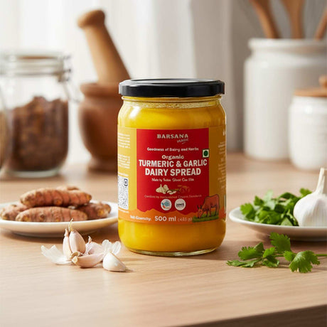 Barsana Magic and Jar of Turmeric & Garlic Dairy Spread on a wooden table with ingredients in the background