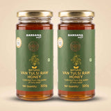 Barsana Magic and Two glass jars of Barsana Magic Natural Van Tulsi Raw Honey with gold lids and green labels, displayed side-by-side on a light beige background.