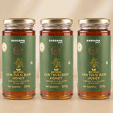 Barsana Magic and Three glass jars of Barsana Organic Natural Van Tulsi Raw Honey arranged side by side on a light beige background.