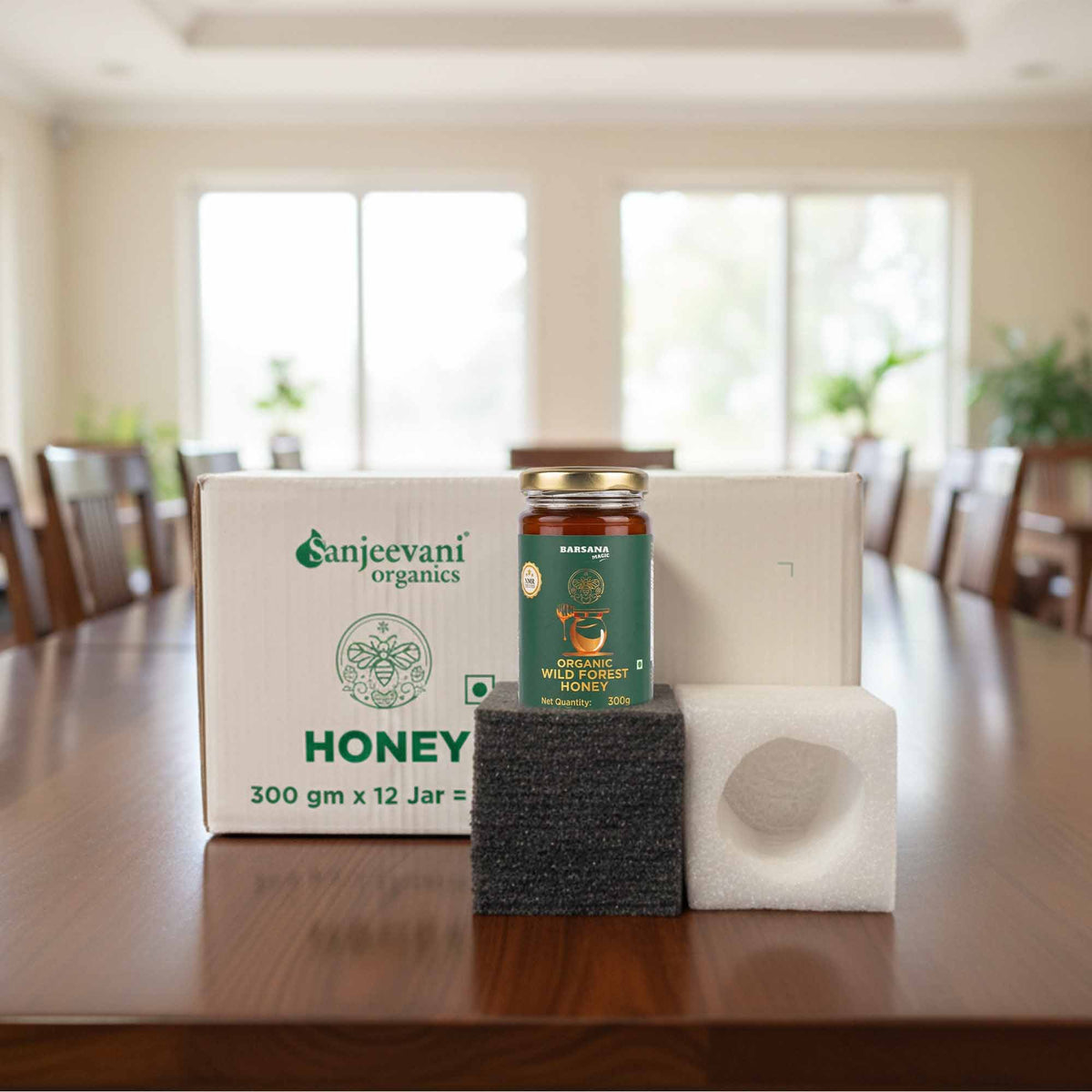 Barsana Magic and Sanjeevani Organics honey jar and packaging on a wooden table with a blurred room background